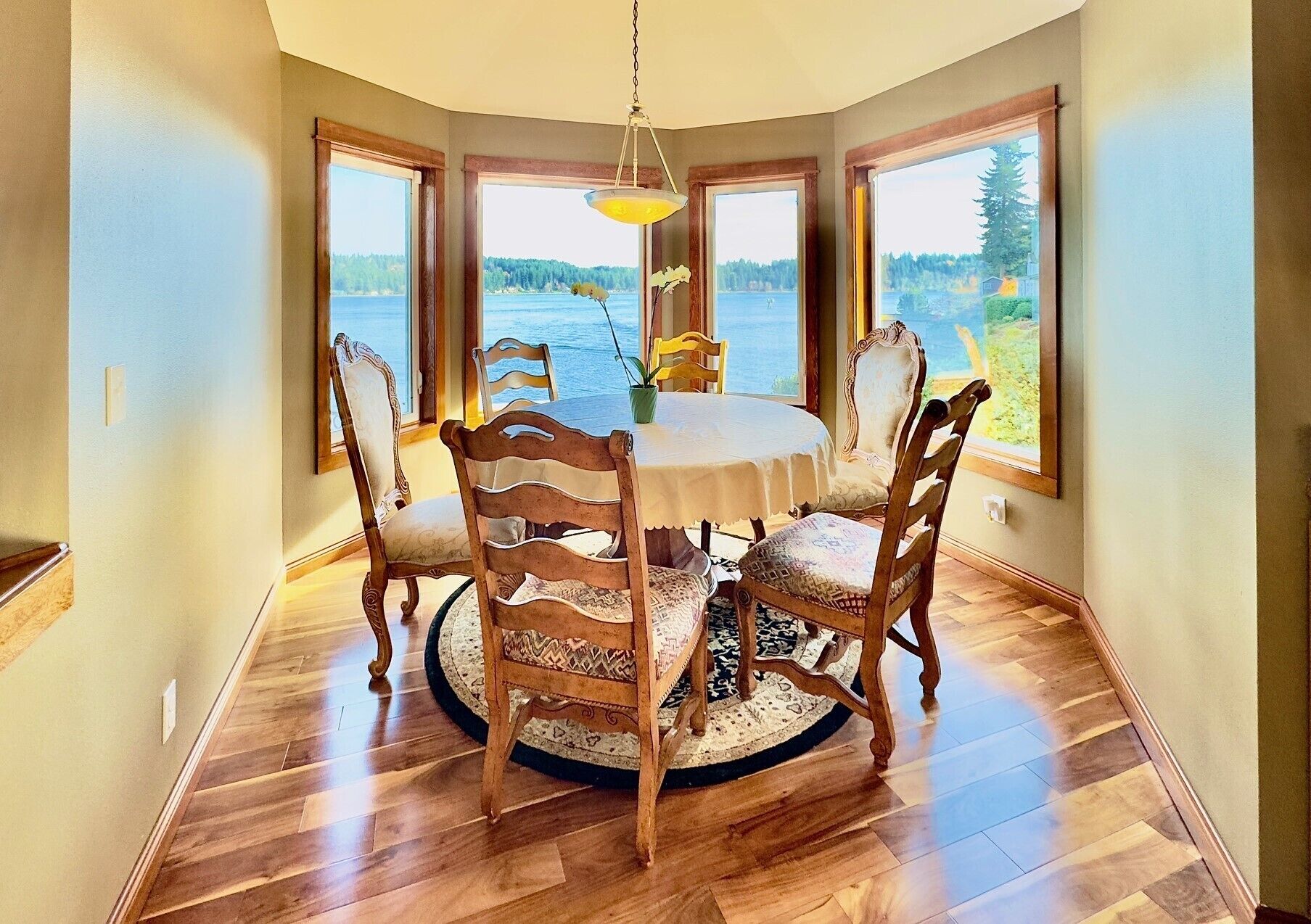 Cozy, sun-filled dining area with large windows and beautiful water views