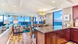 Una cucina moderna con una grande isola, mobili in legno e vista sull'oceano.