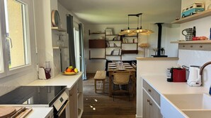 Uma cozinha moderna com área de jantar, piso de madeira e forno embutido.