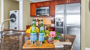 Een keuken met roestvrijstalen apparatuur, houten kastjes, een ingebouwde magnetron en een granieten aanrecht.