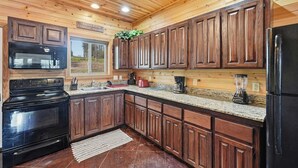 Una cucina con mobili in legno, un piano cottura nero e un frigorifero.