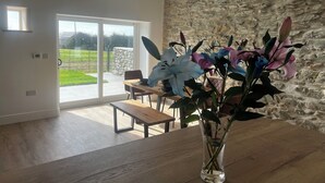 Un interno moderno con una parete in pietra, un tavolo di legno e un vaso di fiori.