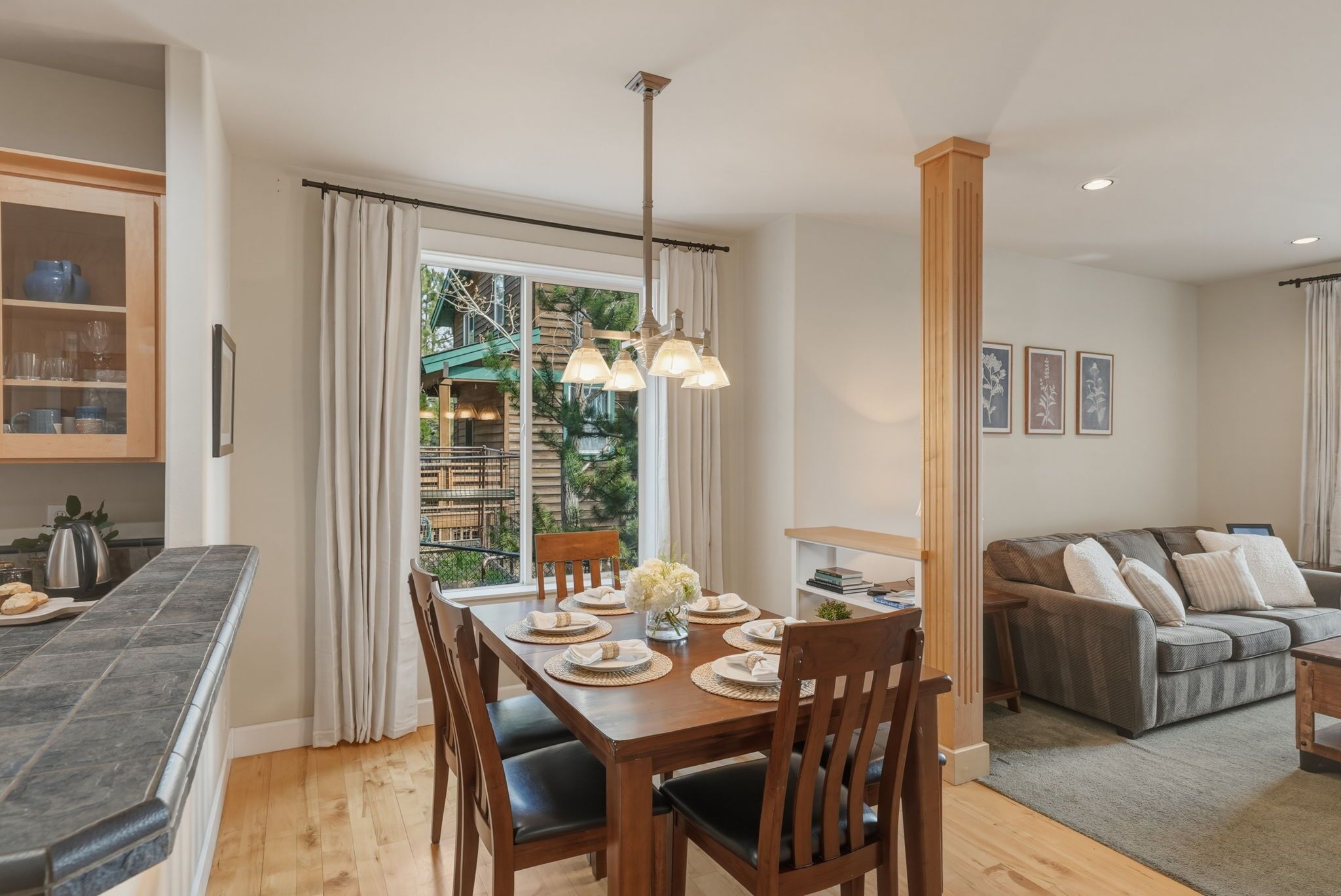 Un espace repas comprenant une table en bois, des chaises et un luminaire suspendu.