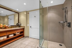 Ein modernes Badezimmer mit einer Duschkabine, einem Holzkosmetikschrank und einer weißen Tür.