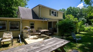 A two-story house with a patio, outdoor furniture, and a grill. - Memory Island on Lamoka (Bradford)