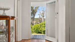 Una puerta que da a un jardín con árboles y vistas al exterior.