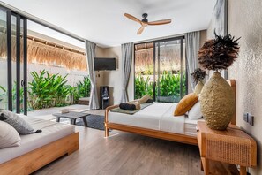 A modern bedroom with a bed, a sofa, a TV, and a ceiling fan. - Thula Lembongan Villa 3 (Lembongan)
