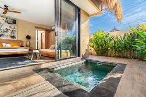 Un espacio exterior moderno con piscina, sofá y mesa de comedor.