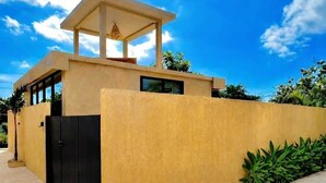 A modern building with a flat roof, a covered entrance, and a large window. - Thula Lembongan Villa 3 (Lembongan)