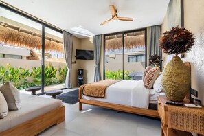 A modern bedroom with a bed, a sofa, a TV, and a ceiling fan. - Thula Lembongan Villa 5 (Lembongan)