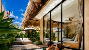 A couple in a swimming pool with a modern house and tropical plants in the background. - Thula Lembongan Villa 5 (Lembongan)