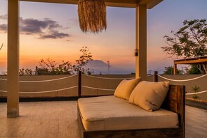 A bed with a view of a sunset and a mountain in the background. - Thula Lembongan Villa 5 (Lembongan)