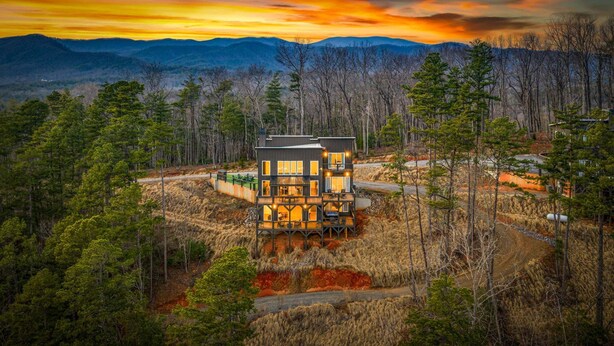 A modern two-story house with a deck, surrounded by a forest and mountains in the background. - 🌄 Blue Ridge Mountain Escape | Scenic Mountain Getaway, Hot Tub & Game Room (Blue Ridge)
