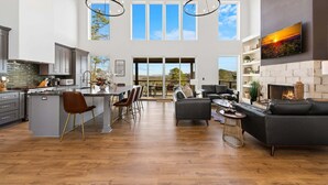 A spacious kitchen with a large island, dining area with chairs, a fireplace, and a living room with a sofa and TV. - 🌄 Blue Ridge Mountain Escape | Scenic Mountain Getaway, Hot Tub & Game Room (Blue Ridge)
