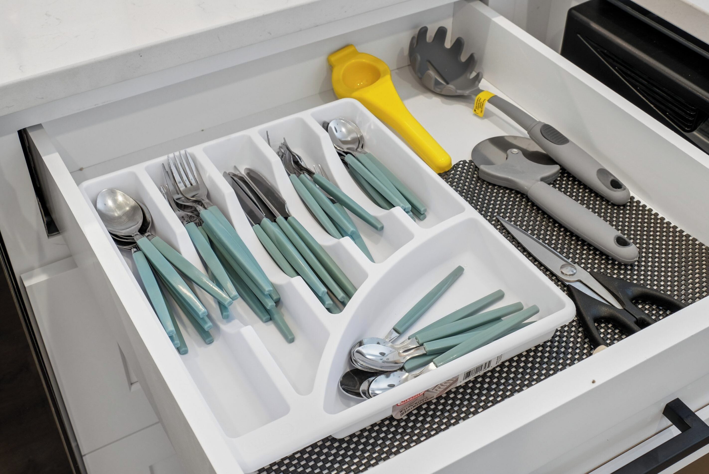 A drawer with utensils and kitchen tools.