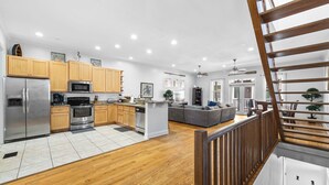 Une cuisine moderne avec des meubles en bois, des appareils électroménagers en acier inoxydable et un îlot central.
