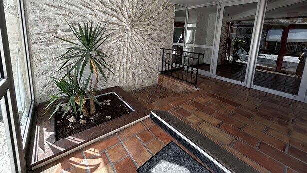 A spacious balcony with a potted plant, a metal railing, and a textured wall. - Air-conditioned studio by the beach - 3 guests (Port Camargue)