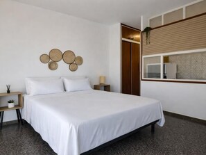 A bedroom with a bed, bedside table, and a wall-mounted circular decoration.