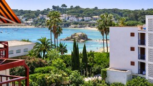 Vista costera con playa, palmeras y edificios.