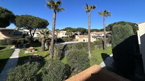 Un quartiere residenziale con palme, un vialetto lastricato e case con tetti in tegole.