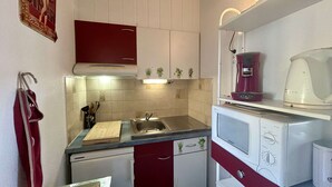 Una cucina compatta con lavello, piano di lavoro, fornello e lavastoviglie.
