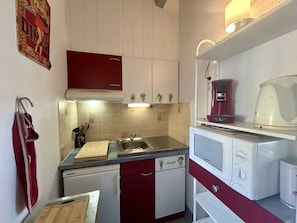 A compact kitchen with a sink, a countertop, a stove, and a dishwasher. - Studio with cabin, AC, parking - 4 guests (Cap d'Agde)