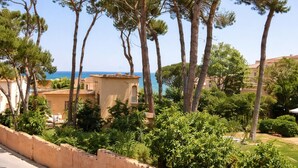 A coastal residential area with pine trees, a clear sky, and a view of the sea. - Family home 50m from the beach - 8 guests (Palamós)
