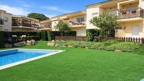 A residential area with a swimming pool, green lawn, and a wooden fence. - Renovated apartment, near beach - 4 guests (Palamós)