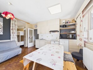 A compact room with a bunk bed, a small kitchenette, a dining table, and a chair. - Charming studio at the slopes - 5 guests (Les Gets)