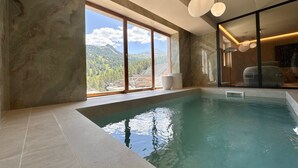 A modern indoor swimming pool with a view of mountains and a large window. - Exceptional Chalet in Vars – 21 guests, 450 sqm, 3 suites (Vars)