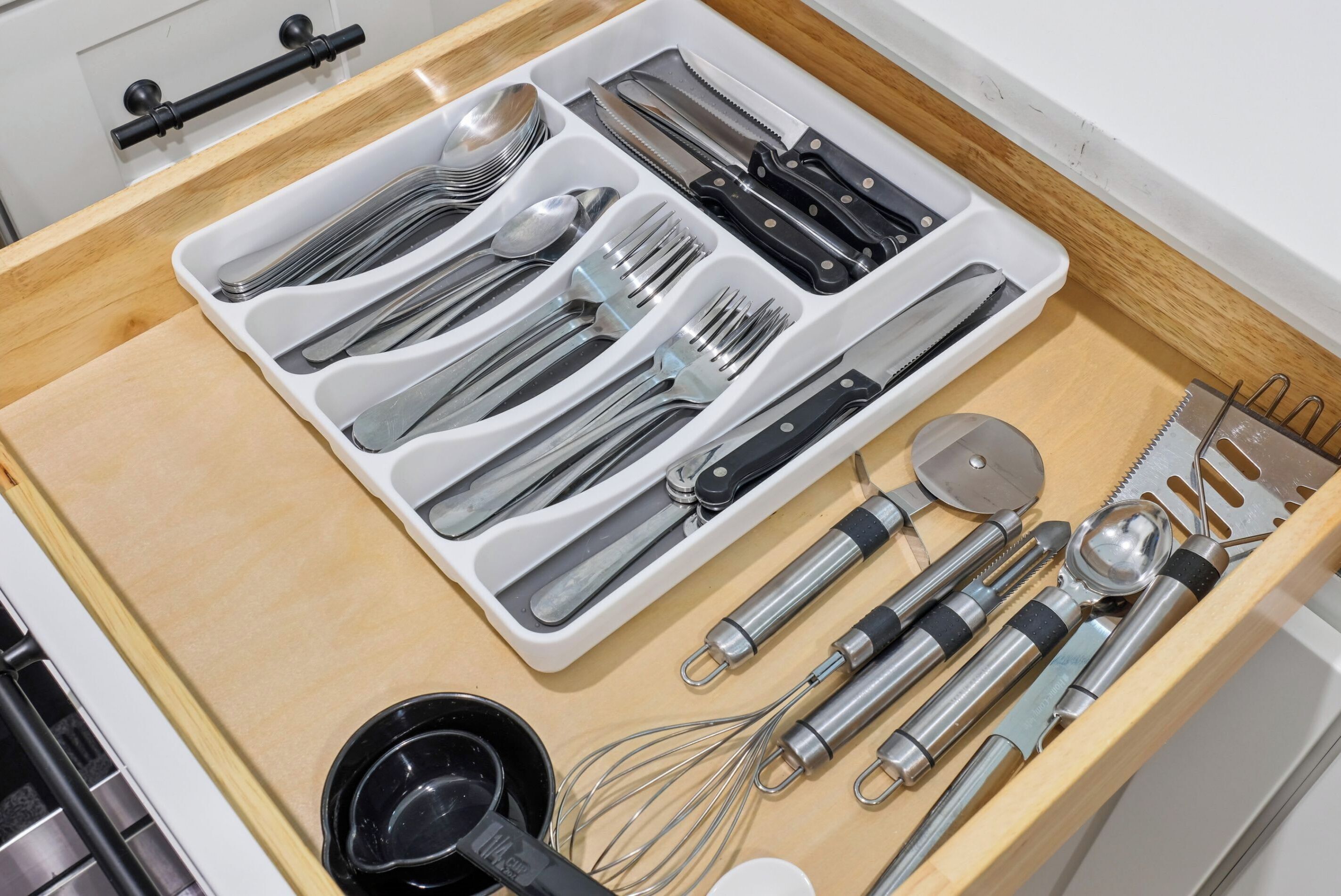 Un cajón de cocina con utensilios y electrodomésticos.