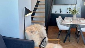 A modern interior with a staircase, dining area, and a sofa. - Innapartments Avenida 60 (Aveiro)