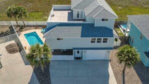 A two-story house with a swimming pool, a fenced yard, and a view of the surrounding landscape. - Port A Beach House | Pool, Game Room and Patio! (Port Aransas)