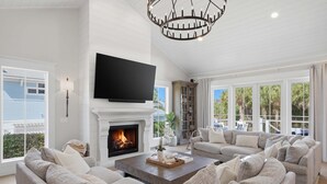 A spacious living room with a fireplace, a large flat-screen TV, and a comfortable seating area. - Wagon Wheeler 6 Bed 4 Bath Private Pool Close to Gulf & Village Sleeps 12 (Boca Grande)