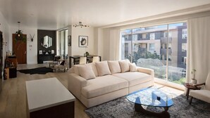 A modern living room with a sofa, coffee table, and dining area. - Luxury Hollywood Condo, 2 King Suites, Pool (Los Angeles)
