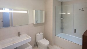 A modern bathroom with a glass-enclosed shower, a white sink, and a toilet. - Luxury Hollywood Condo, 2 King Suites, Pool (Los Angeles)