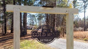 Un cartello di legno con la scritta 'GOLD MINE RETREAT'.
