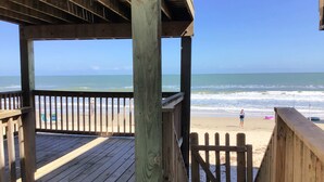 Un pontile di legno che conduce a una spiaggia con vista sull'oceano.