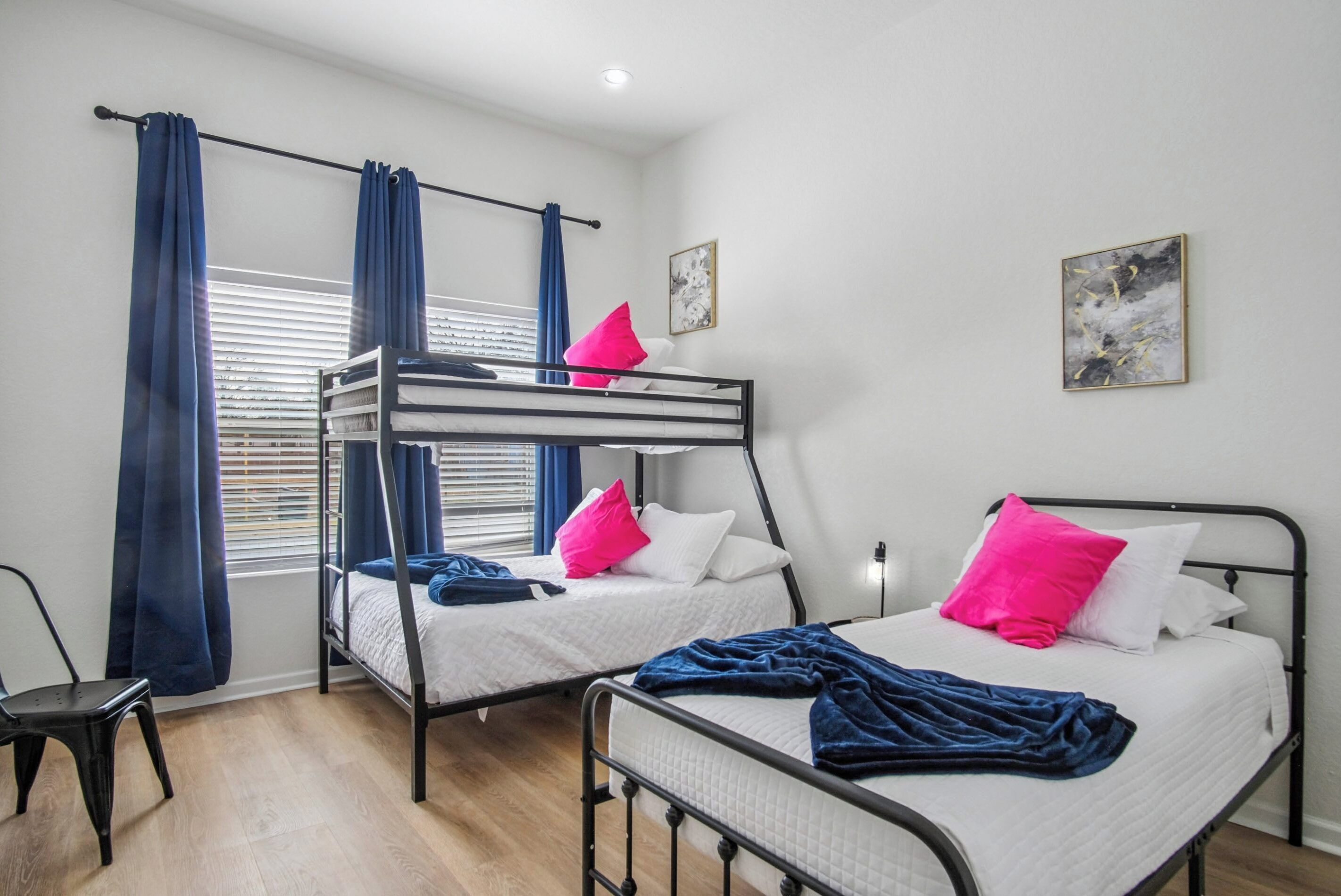 Une chambre avec des lits superposés, une chaise et une fenêtre avec des rideaux.