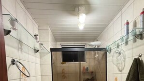 Ein kleines Badezimmer mit Dusche, Toilette und Handtuchhalter.