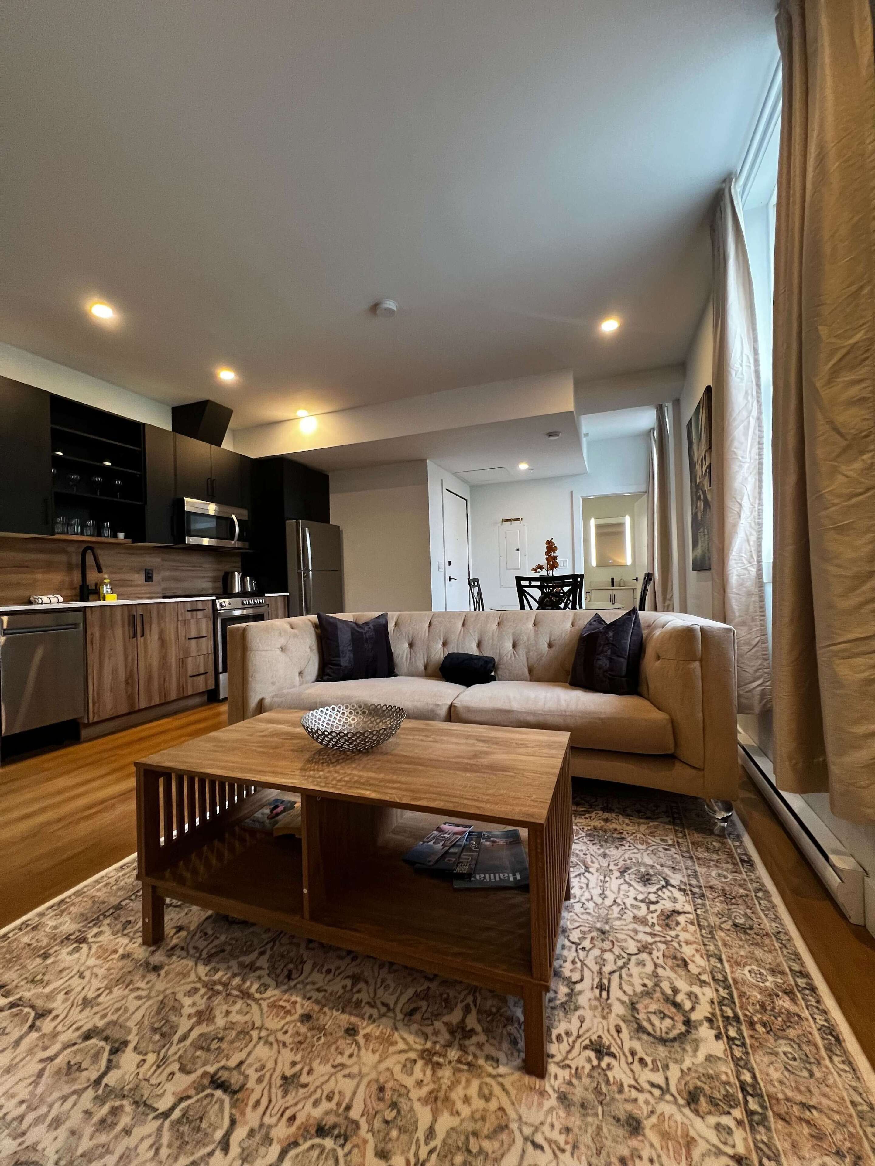 Un salon moderne avec un canapé, une table basse et un tapis à motifs.
