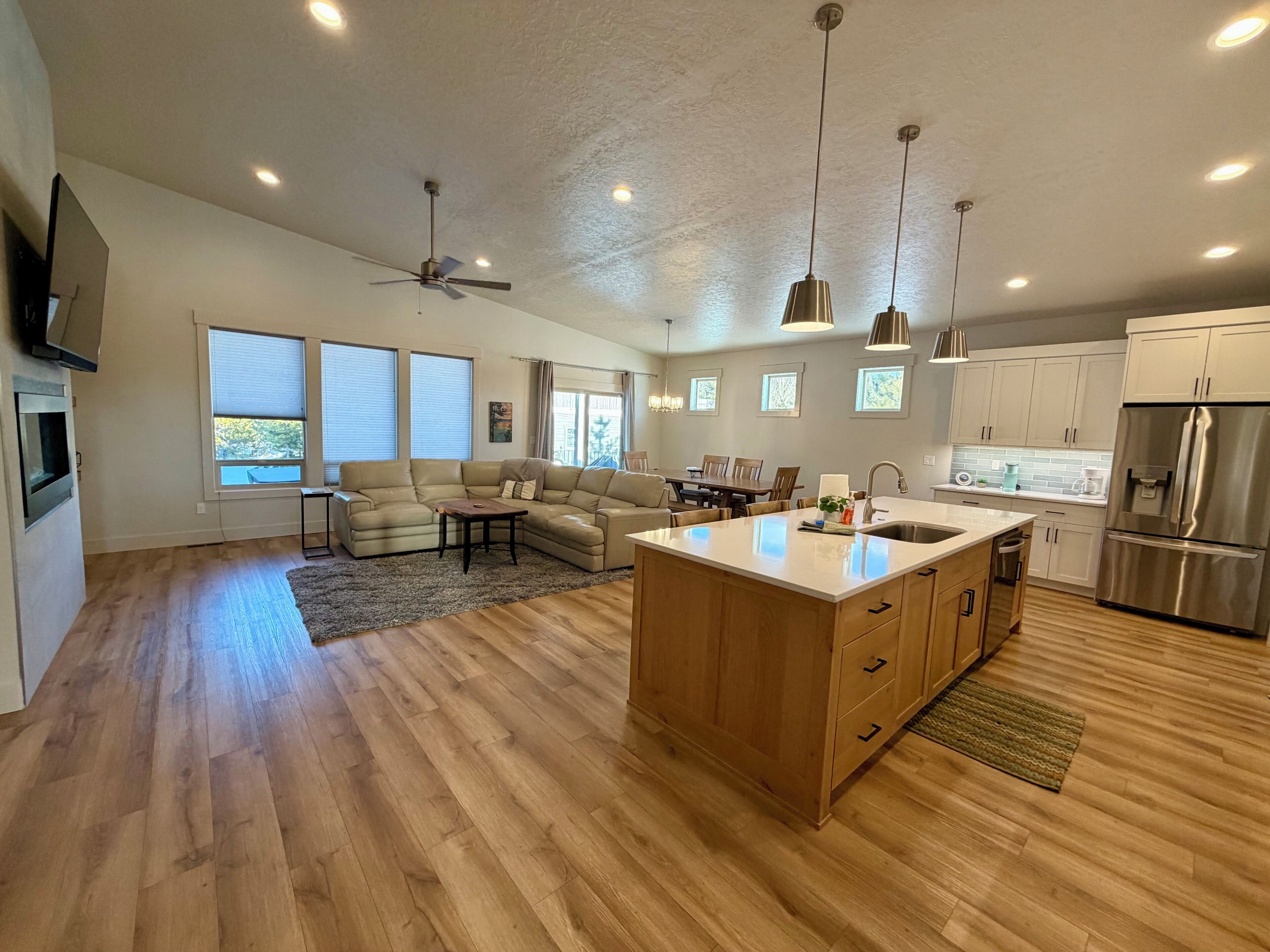 A modern kitchen with a central island, wooden flooring, and built-in cabinets.