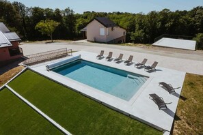 A rectangular swimming pool with a surrounding deck, a house in the background, and a grassy area in the foreground. - Stay among vineyards with private sauna and nature views (Kutina)