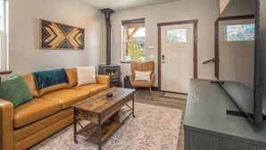 A living room with a sofa, coffee table, and a fireplace. - NEW! Town Center Basecamp at Big Sky | Walk to Dining, Shops & Events | Prime Location (Big Sky)