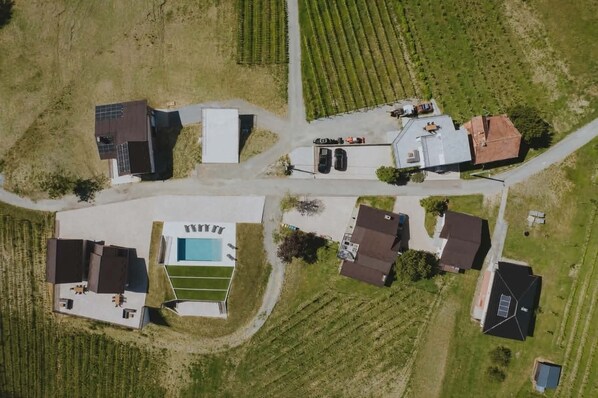 An aerial view of a residential area with houses, a swimming pool, and a road.