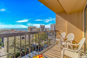 A balcony with a view of the sea, white chairs, and a table. - Ocean Dunes Tower I - Unit 4054 (Myrtle Beach)