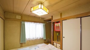 A room with a bed, a window with curtains, a wooden ceiling, and a traditional Japanese-style door. - [Sapporo Private House ] 8-minute walk from subway station and airport bus stop (Sapporo)