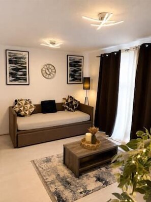 A living room with a sofa, a coffee table, and artwork on the walls. - Flat in Manchester – Dudley's Dove (Manchester)