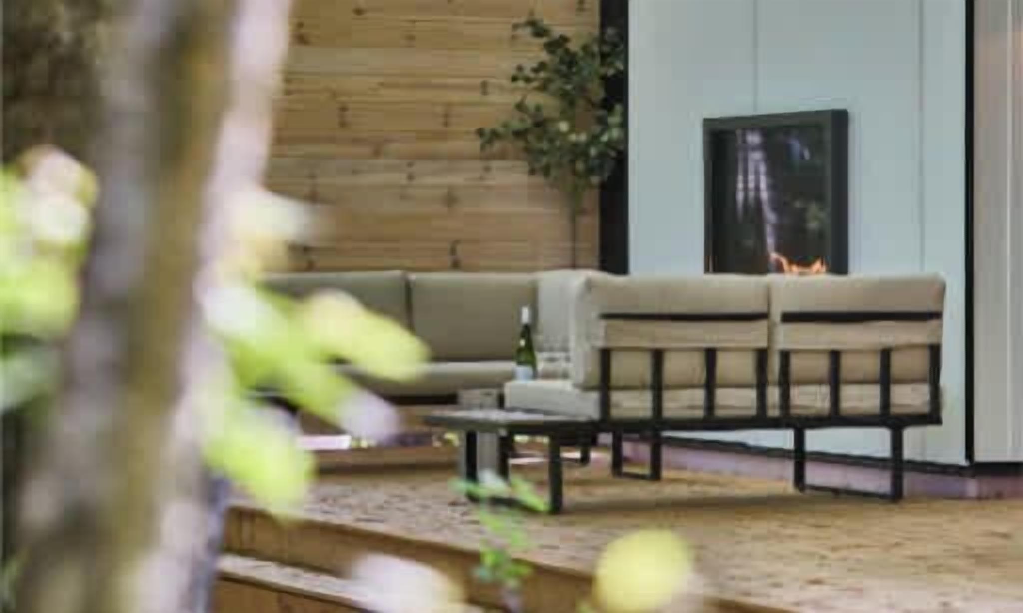 A modern living room with a sofa, a coffee table, and a fireplace.