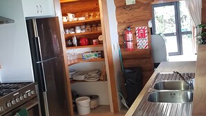 A kitchen with a refrigerator, stove, and sink. - Stunning Tidal Waters Loglodge (Tolaga Bay)